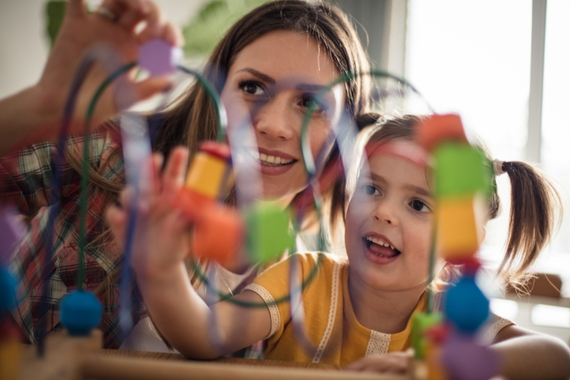 Early years practitioner with child learning